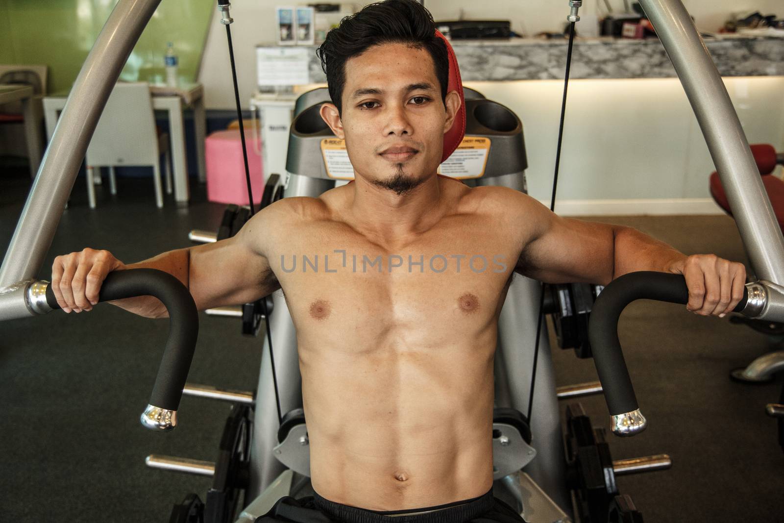 Man is exercising with machine bench press by letoakin