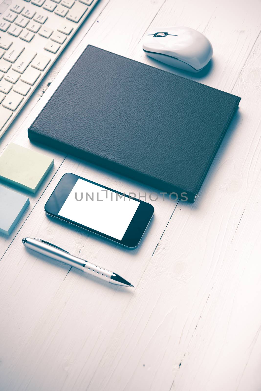 computer and brown notebook with office supplies on white table vintage style