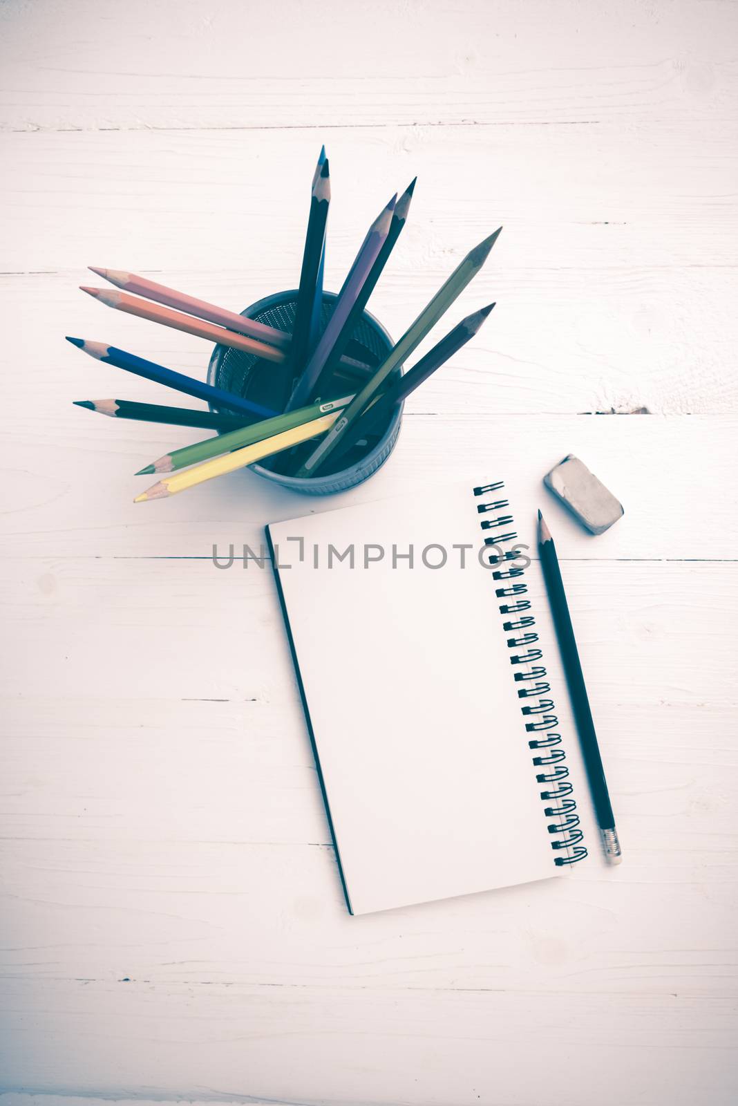 notepad with color pencil on white table view from above vintage style