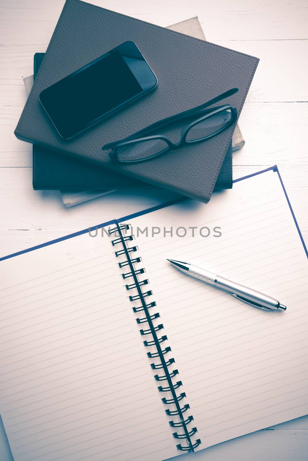 notepad with stack of book on white table view from above vintage style