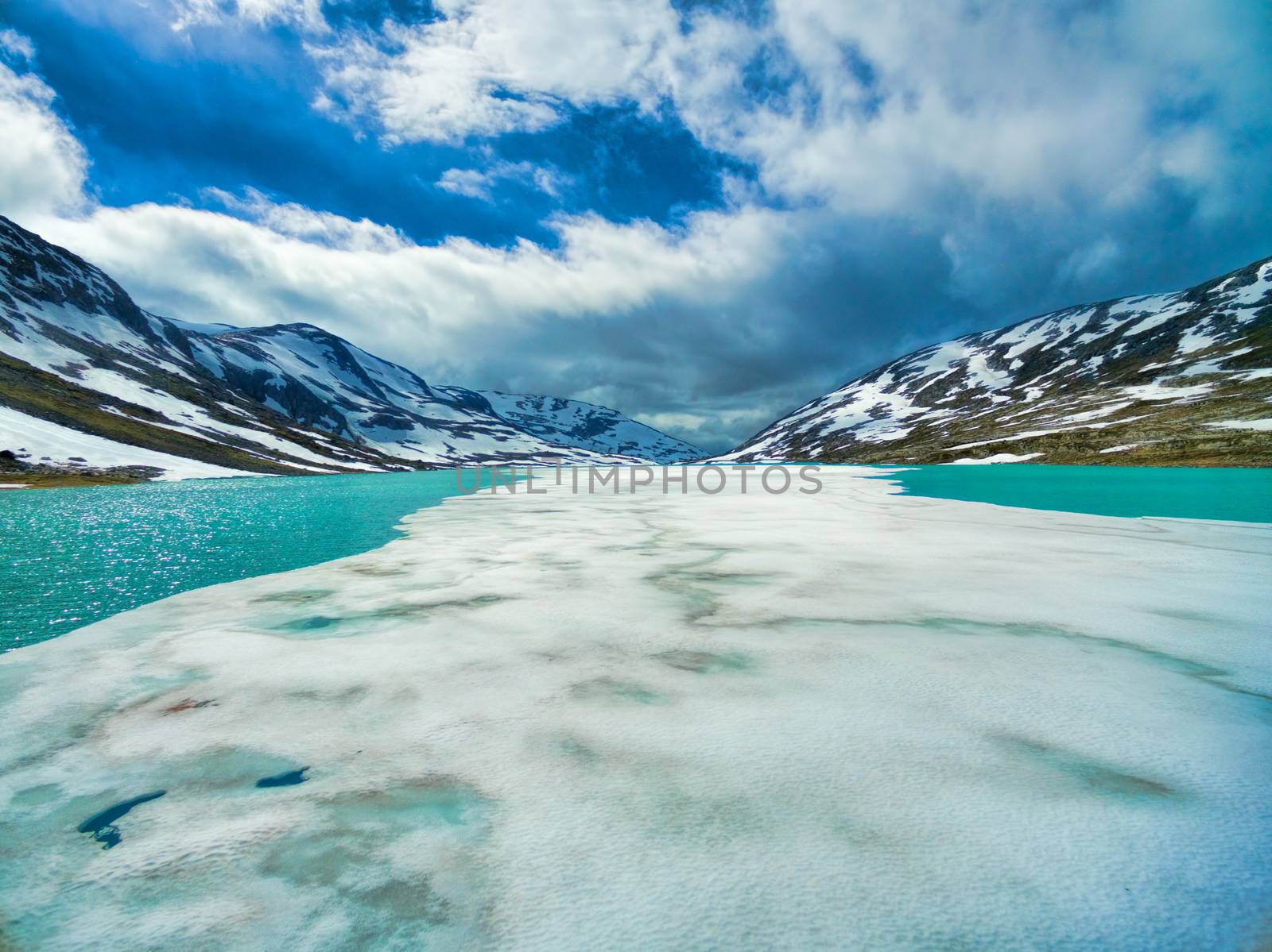 Thin ice on partly frozen lake in norwegian mountains on Gamle Strynefjellsvegen mountain pass