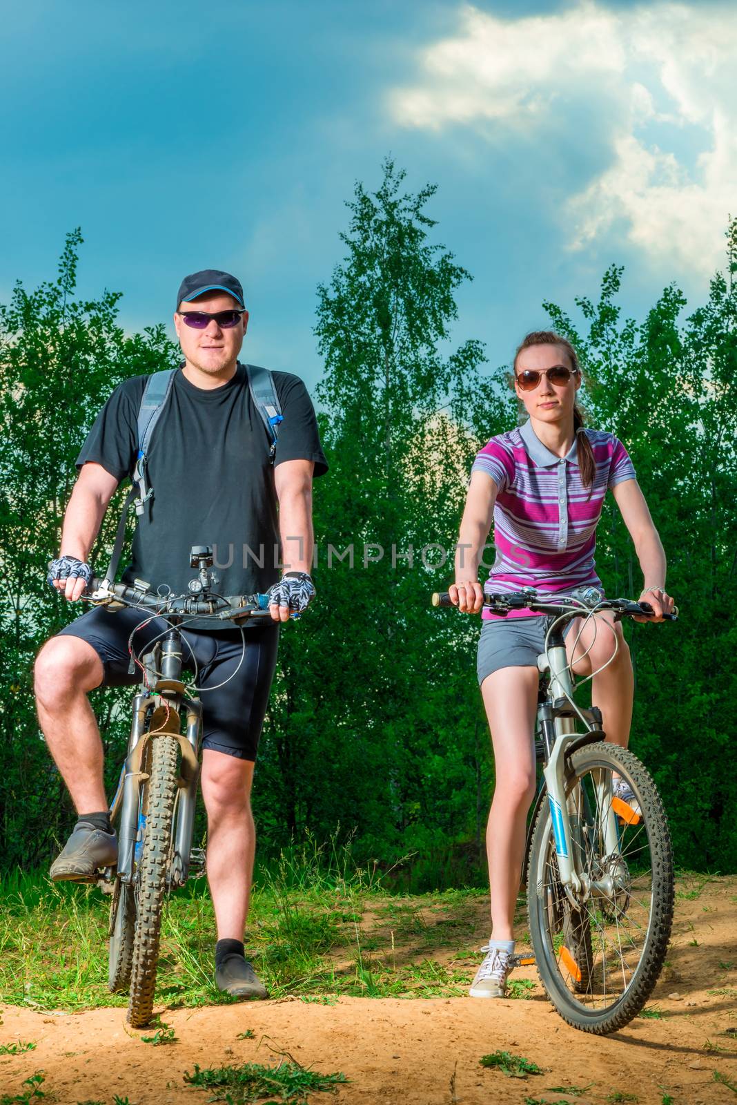man and woman with bicycles on a country road by kosmsos111