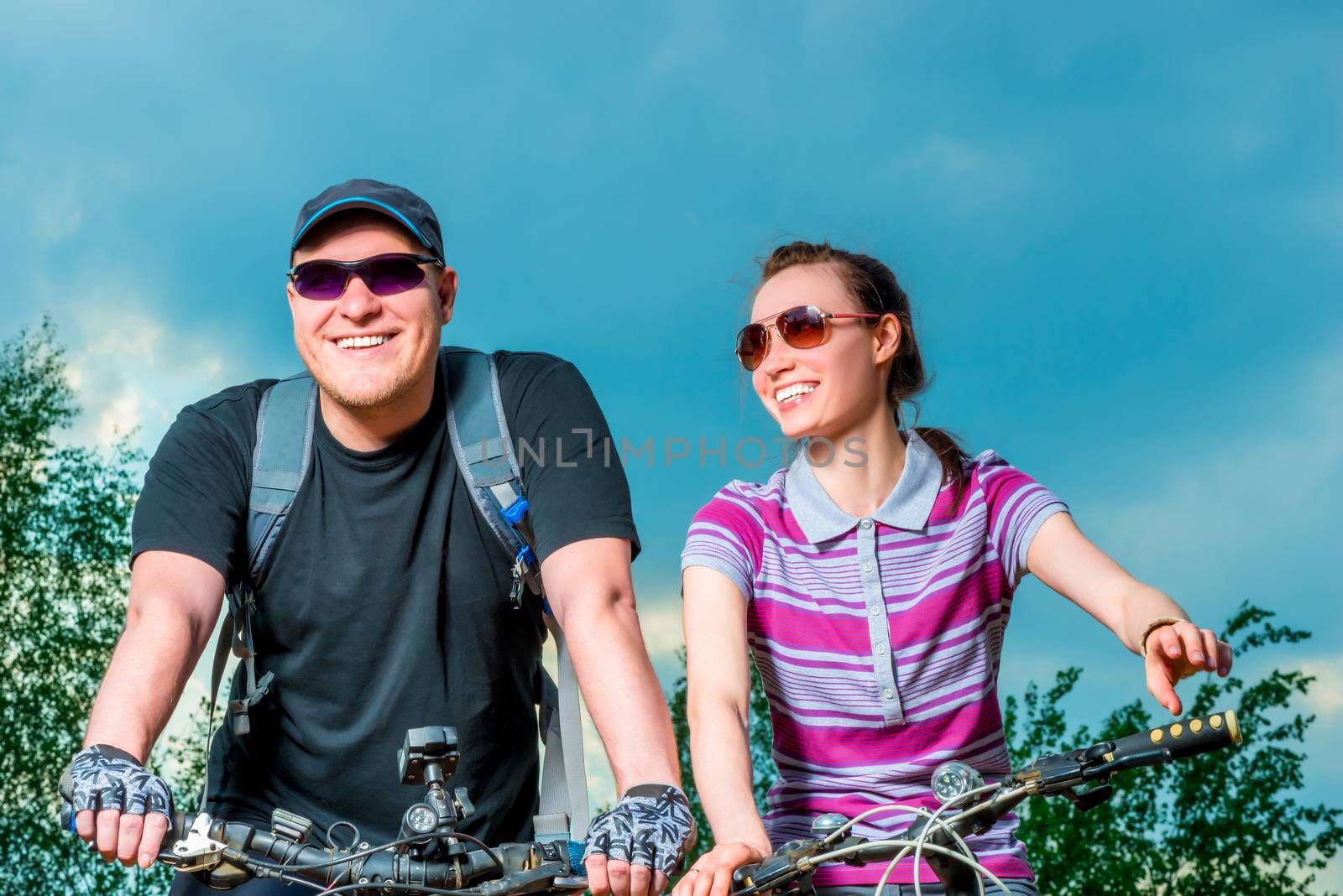 happy couple on the bike on the background of blue sky by kosmsos111