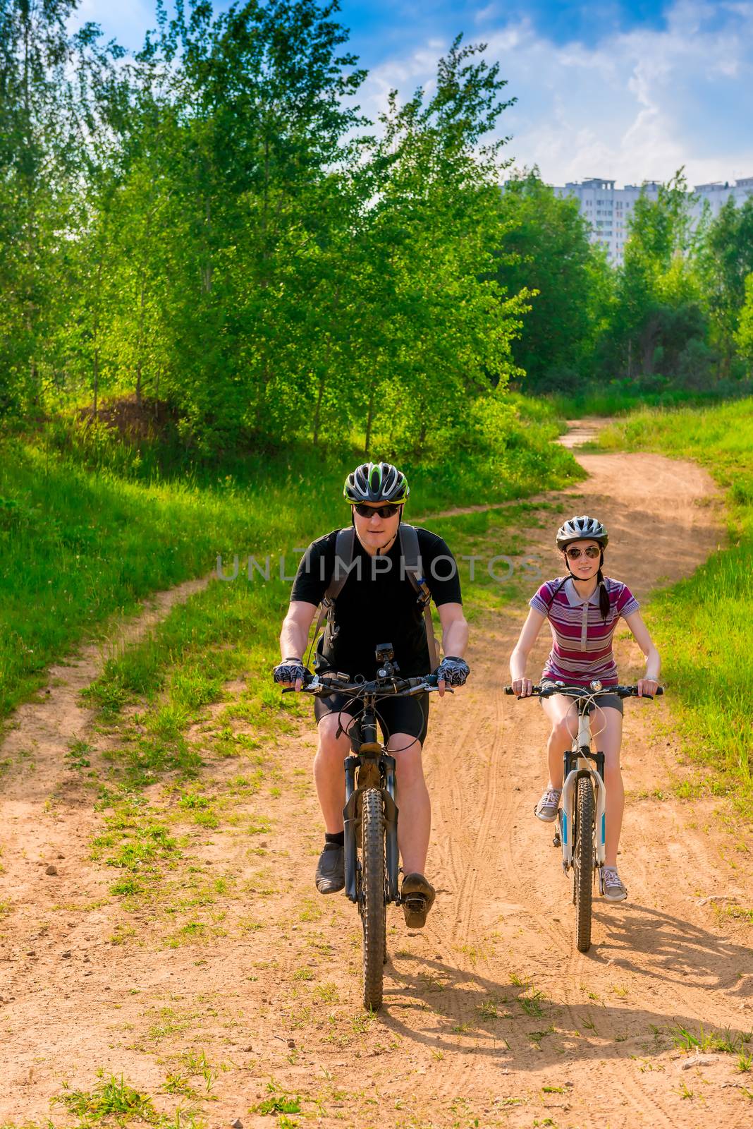 Male cyclist in helmet with a backpack and his girlfriend
