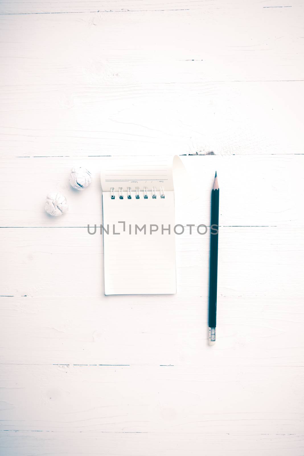 notepad with crumpled paper and pencil over white table vintage style