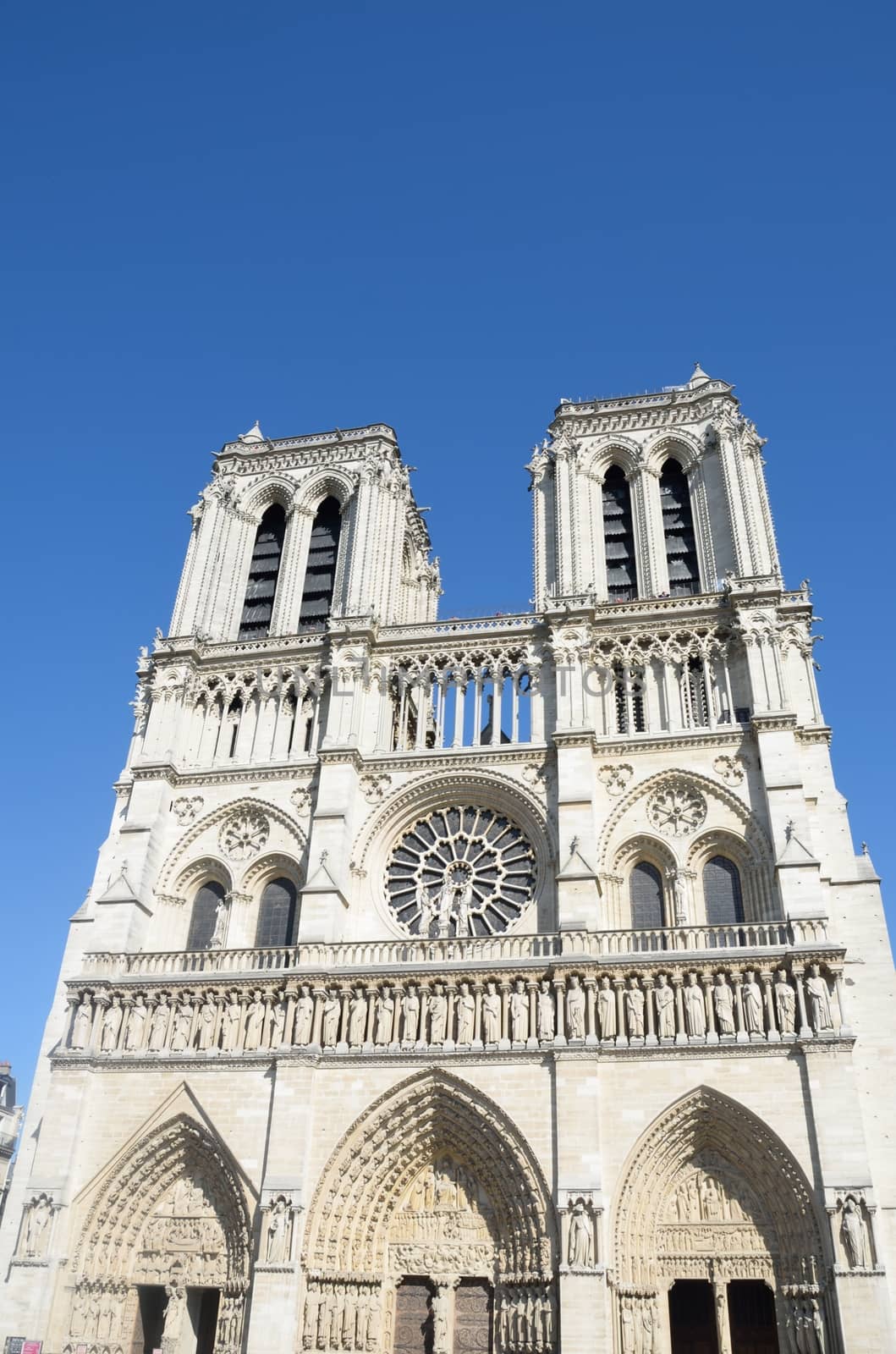 Front of Notre Dame Cathedral with bright blue sky in background