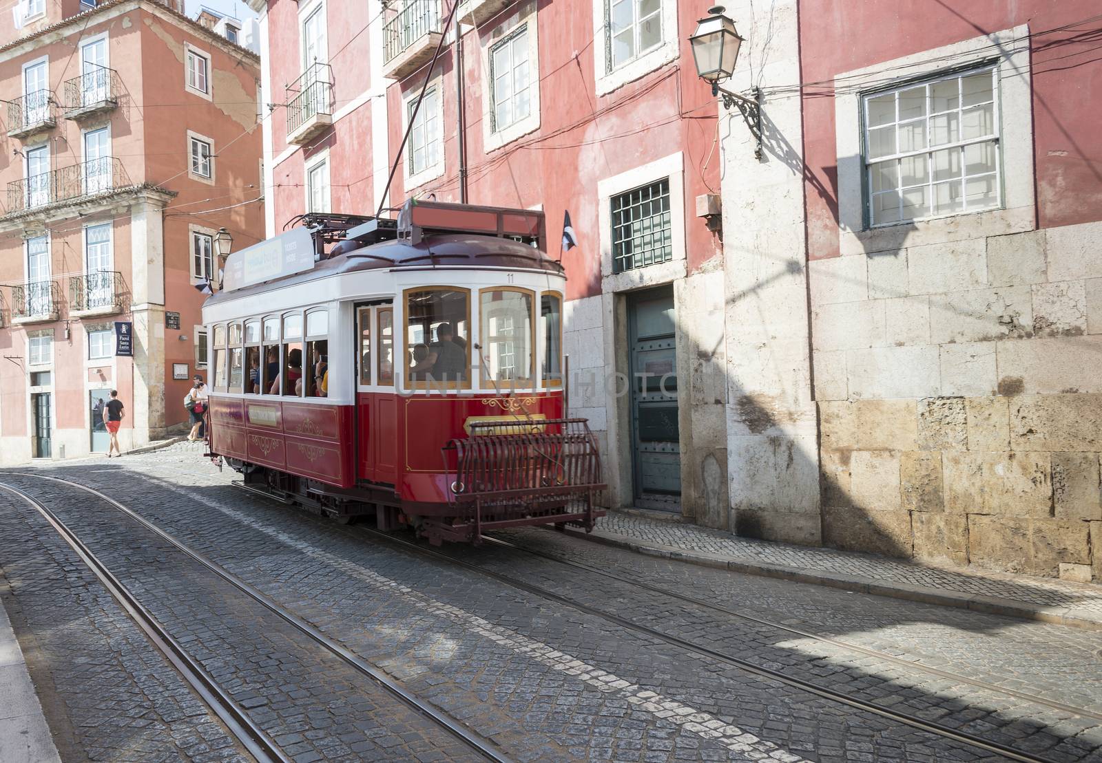 LISBON, PORTUGAL - SEPTEMBER 26: Unidentified people sitting in the red tram  goes by the street of Lisbon city center on September 26, 2015. Lisbon is a capital and must famous city of Portugal