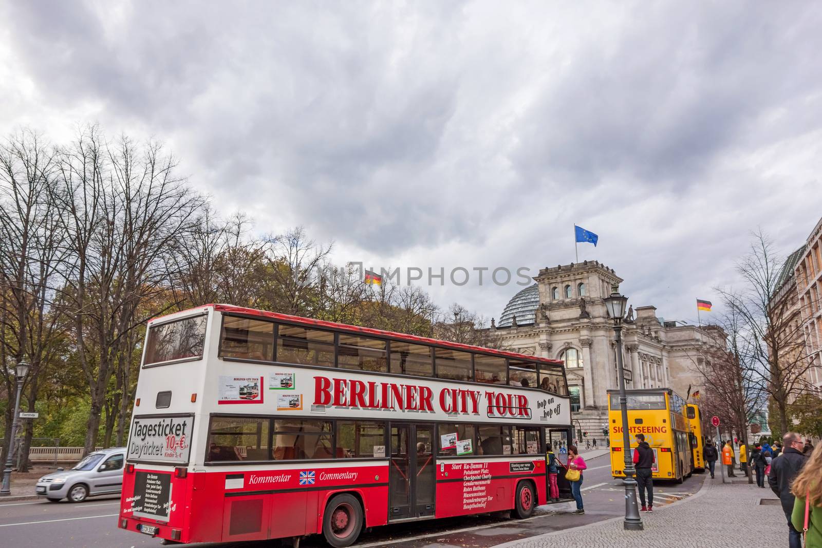 Berlin, Germany - October 28, 2013: Sightseeing buses in front of the Reichstag building. The different bus companies approach the most interesting places of Berlin.
