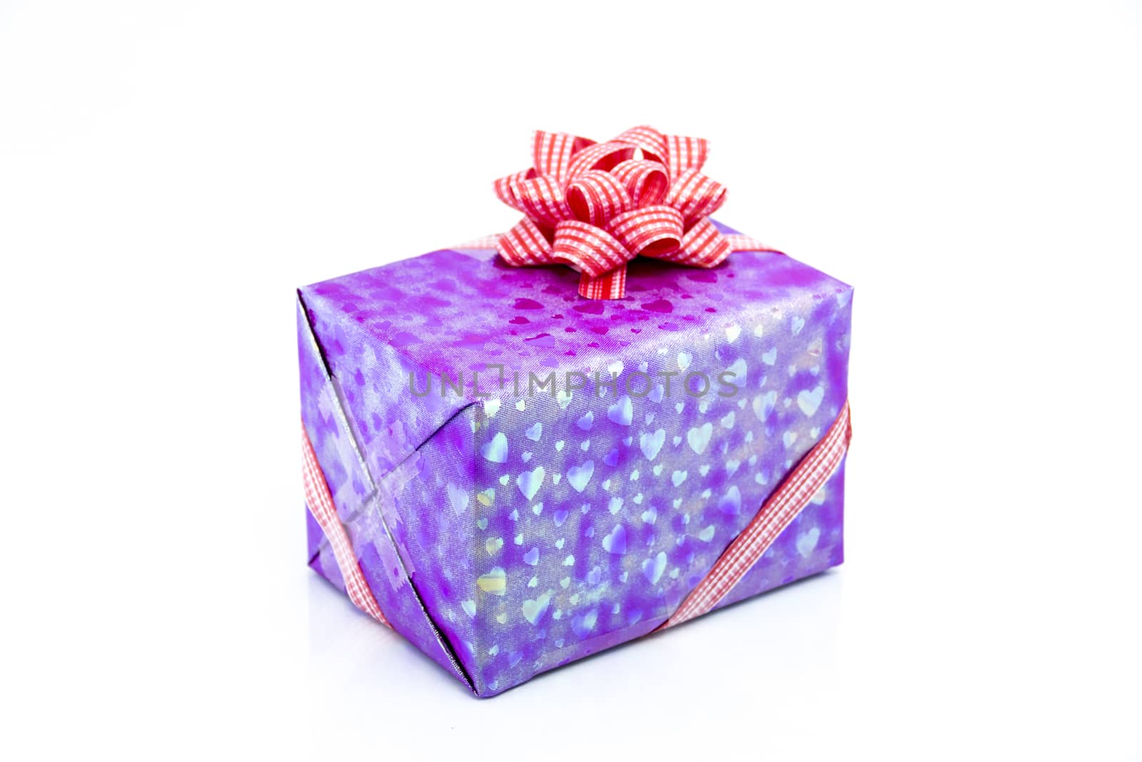 pink gift box with red ribbon bow by teerawit