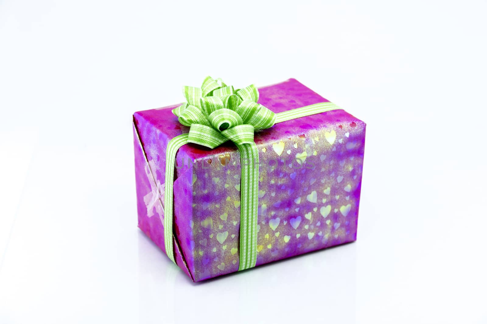 pink gift box with green ribbon bow by teerawit