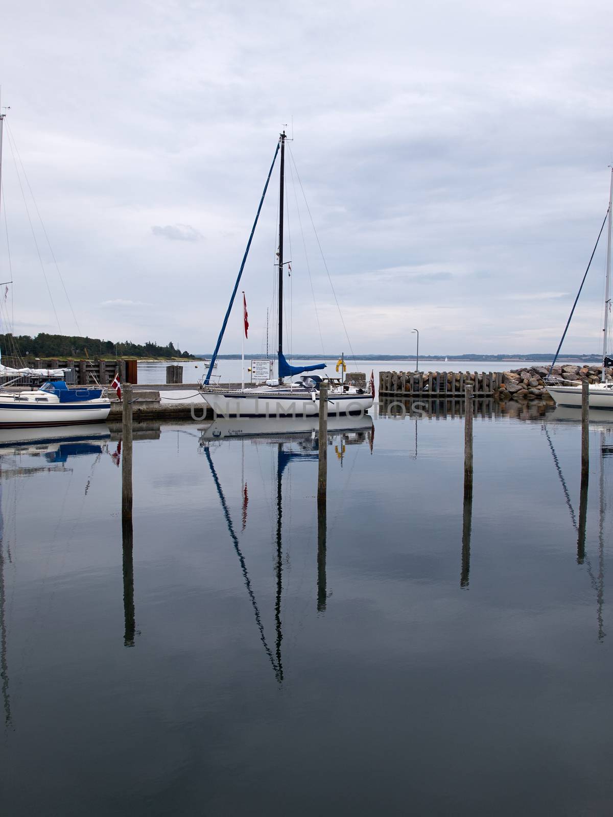 Recreational Sail Yacht in a small marina with reflection in the water     