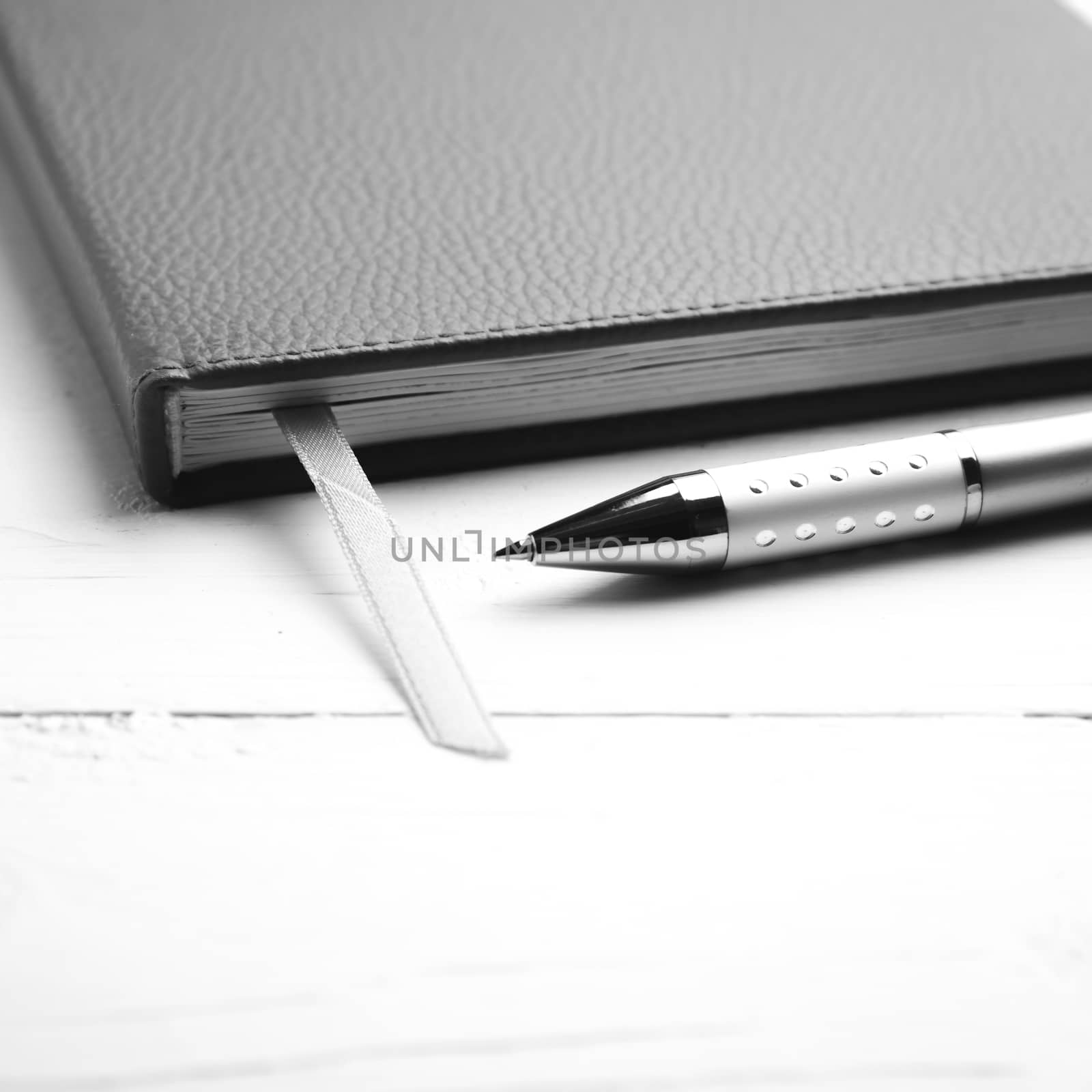 notebook and pen over white table black and white tone color style