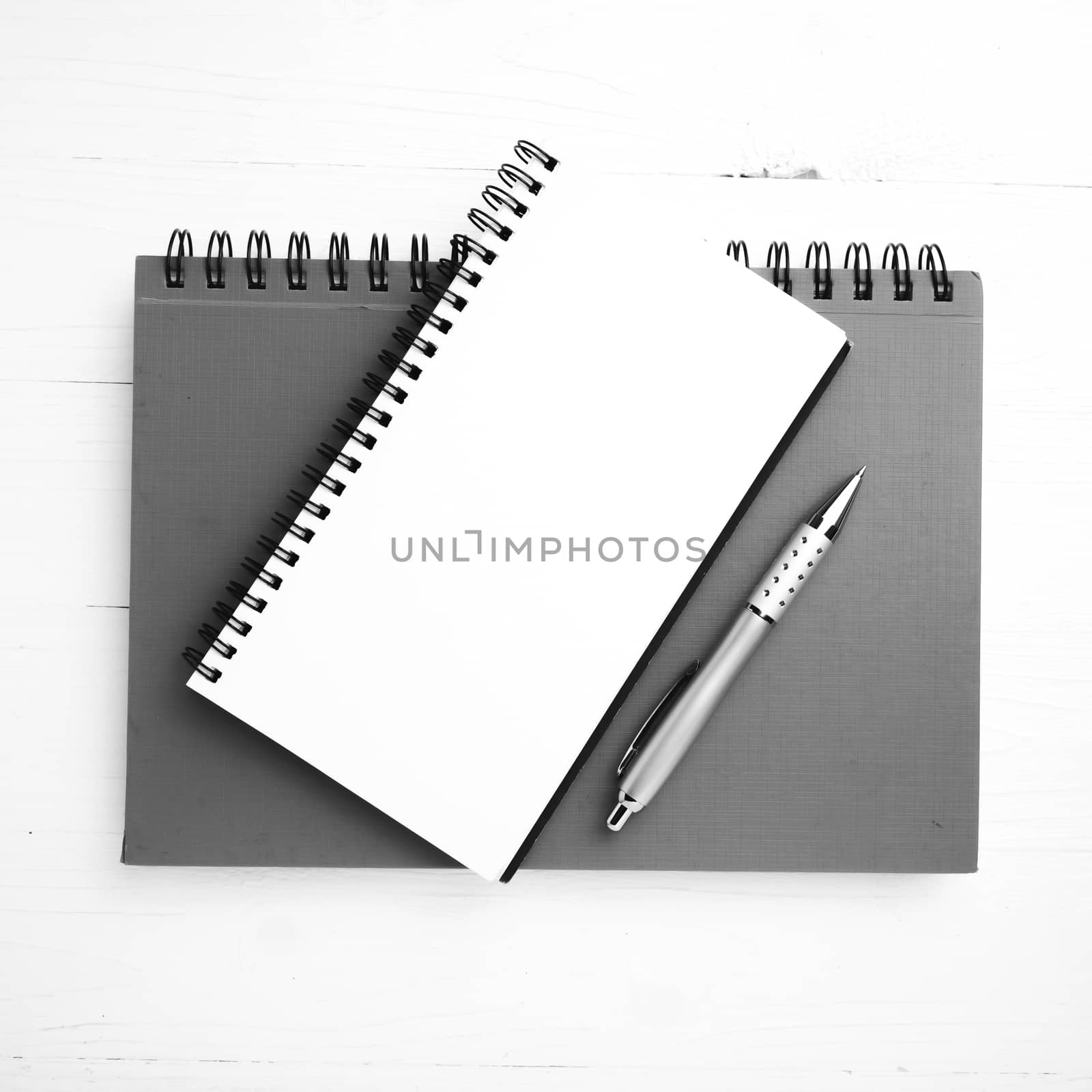 notebook and pen over white table black and white tone color style