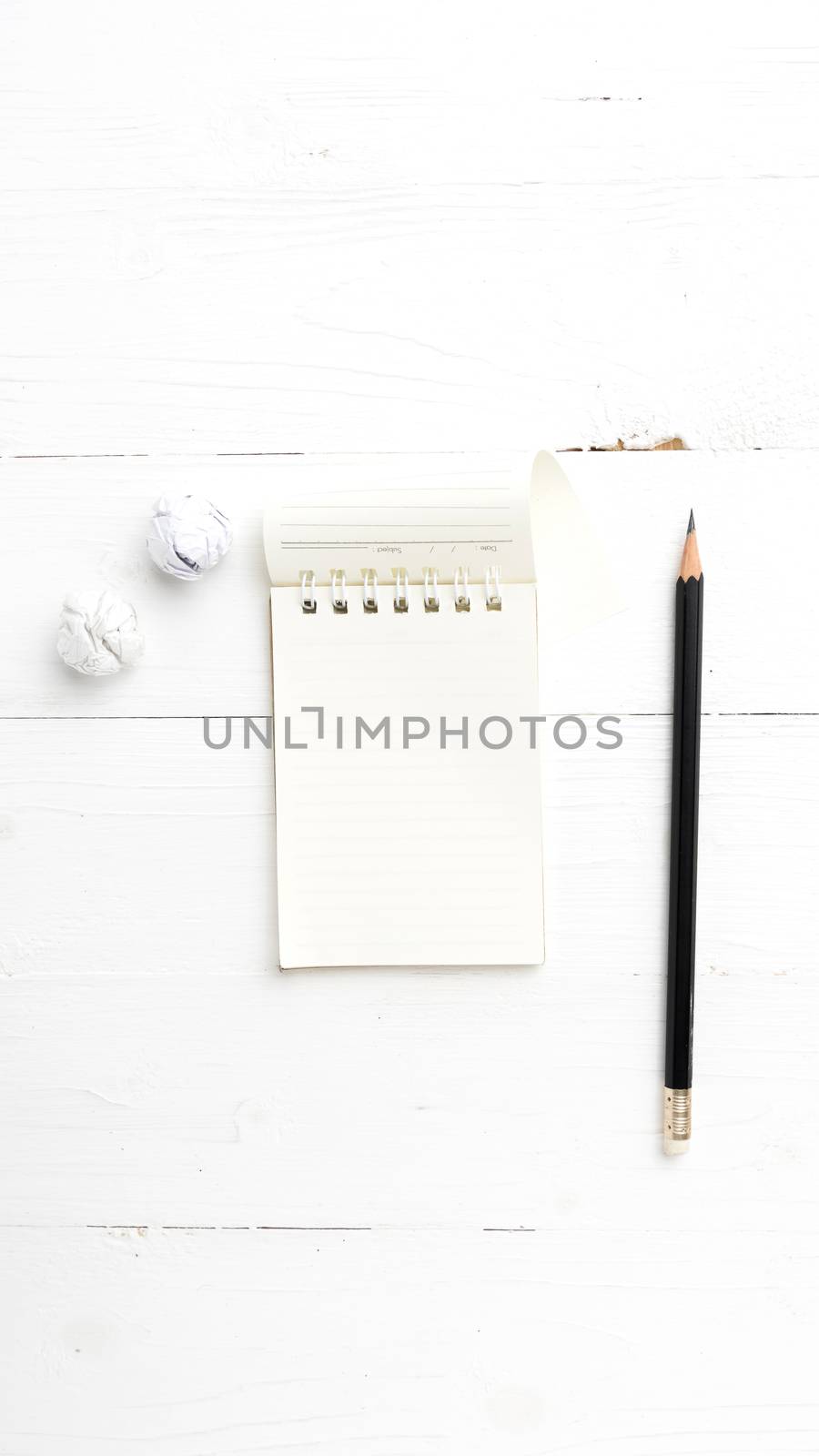 notepad with crumpled paper and pencil over white table