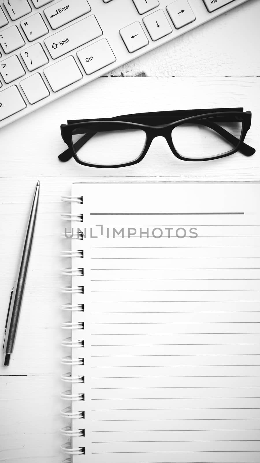 computer and notepad over white table black and white tone color style