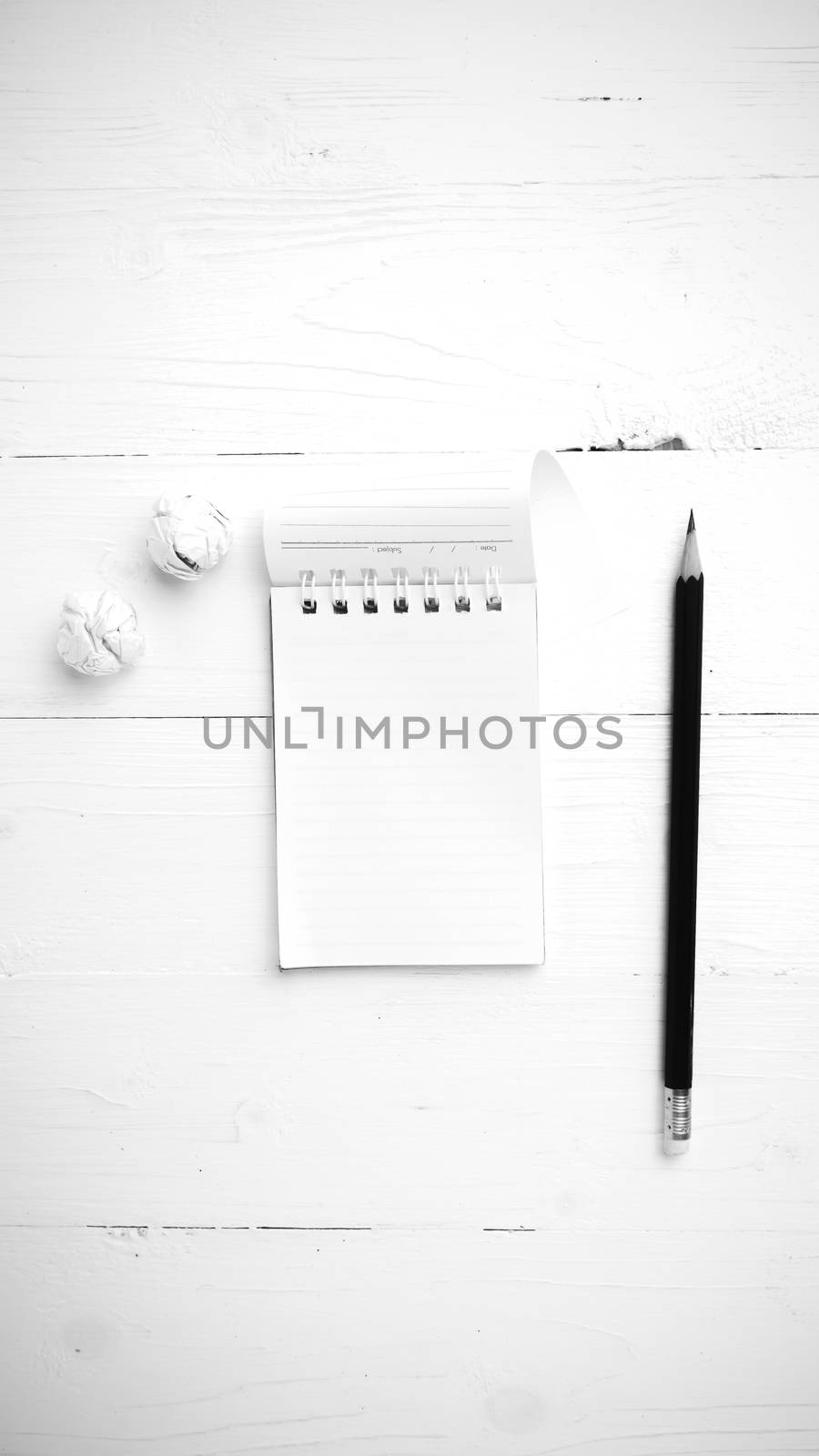 notepad with crumpled paper and pencil over white table black and white tone color style