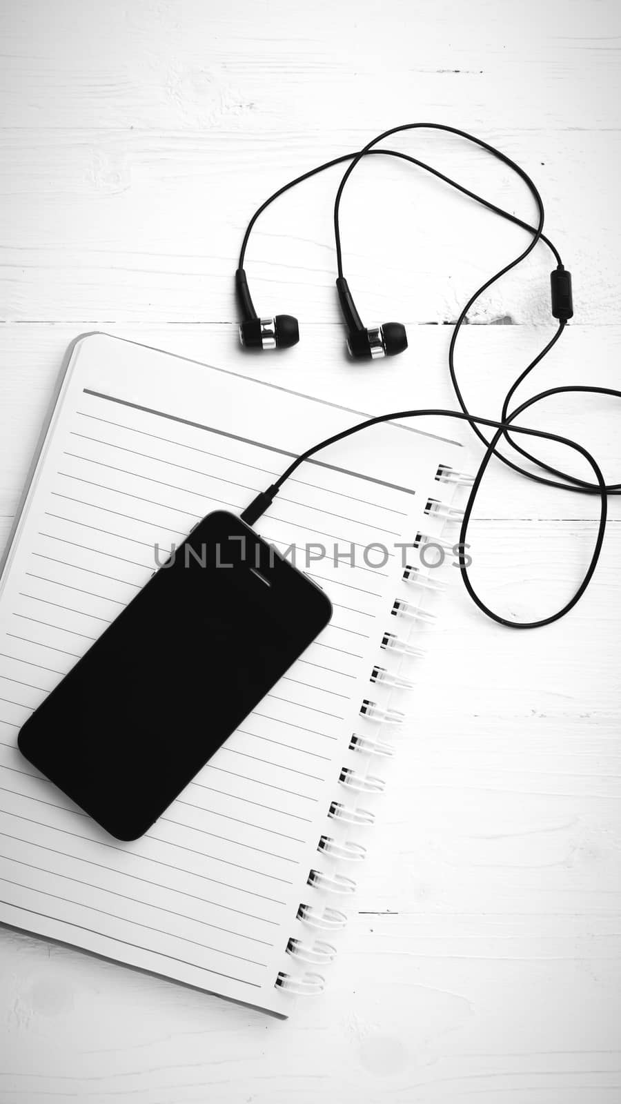 notepad and cellphone over white table black and white color tone style