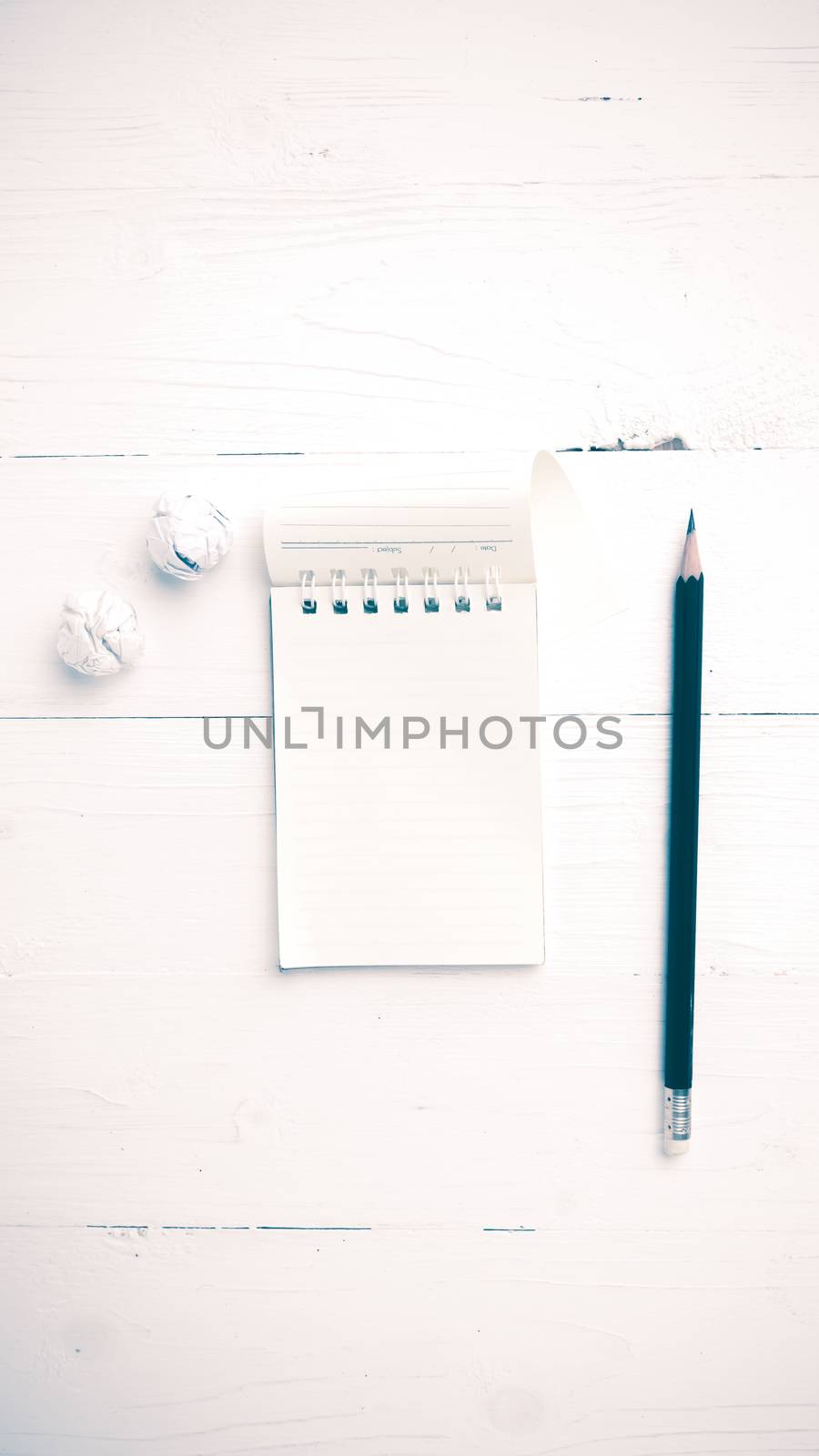 notepad with crumpled paper and pencil over white table vintage style