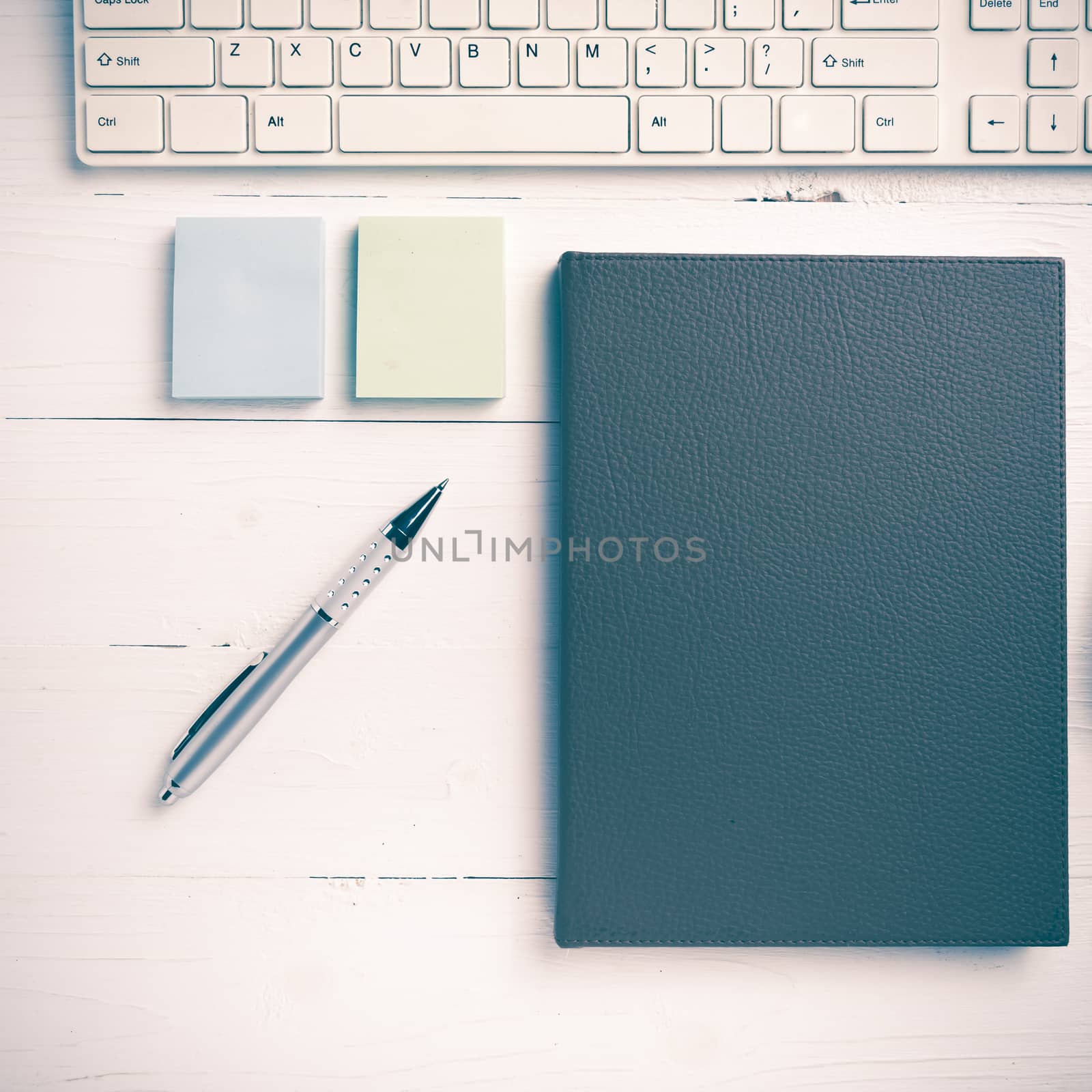 computer and brown notebook with office supplies on white table vintage style