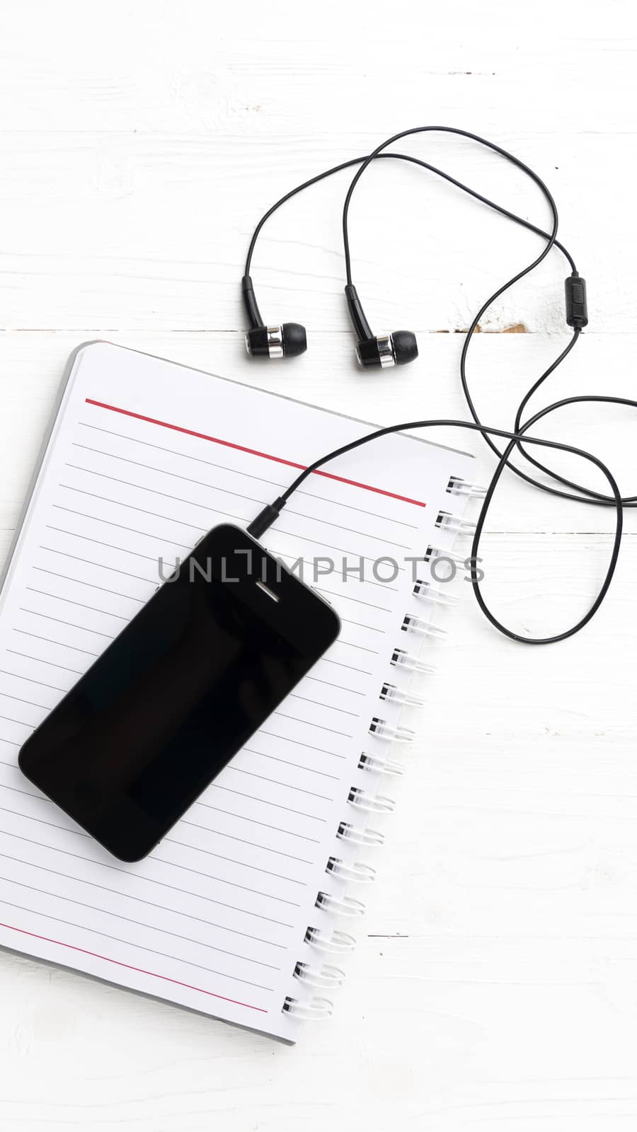 notepad and cellphone over white table