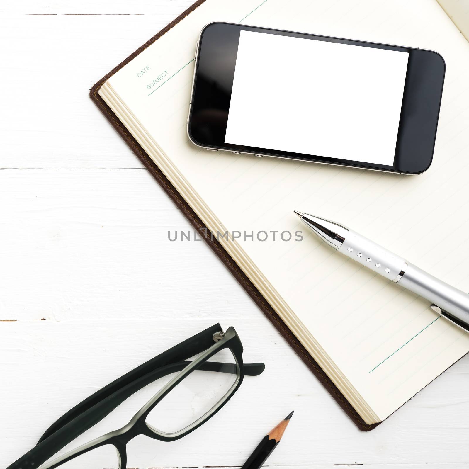 smart phone on notebook over white table