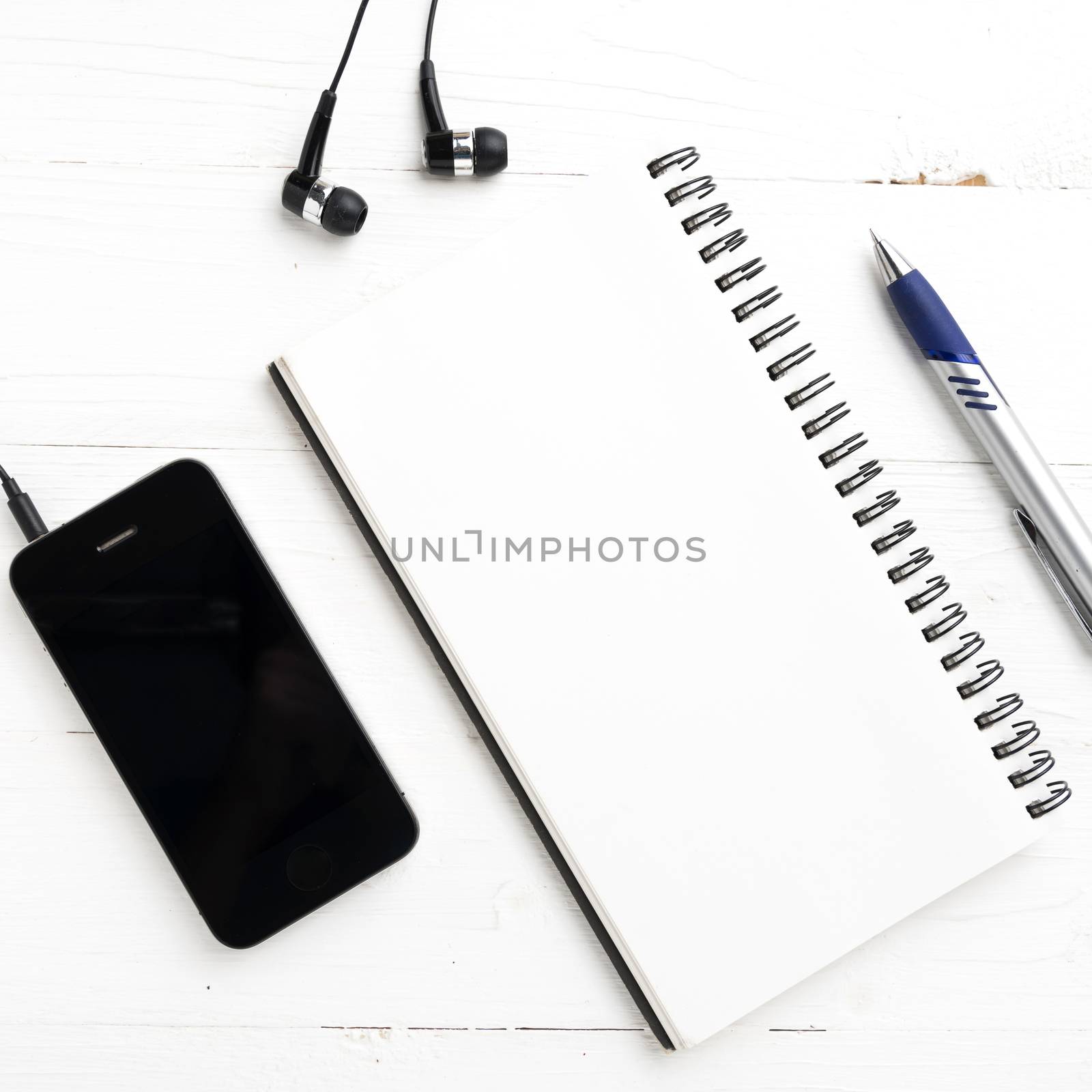 notepad and cellphone over white table