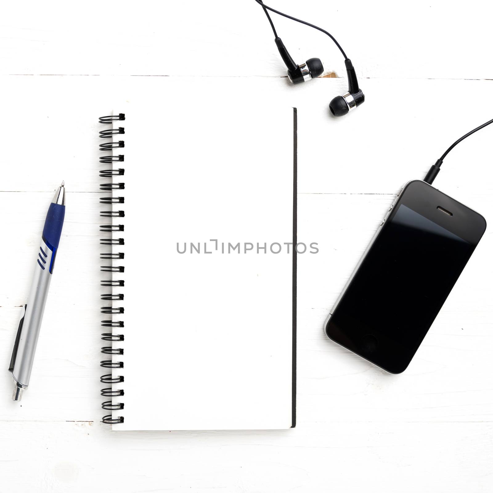 notepad and cellphone over white table