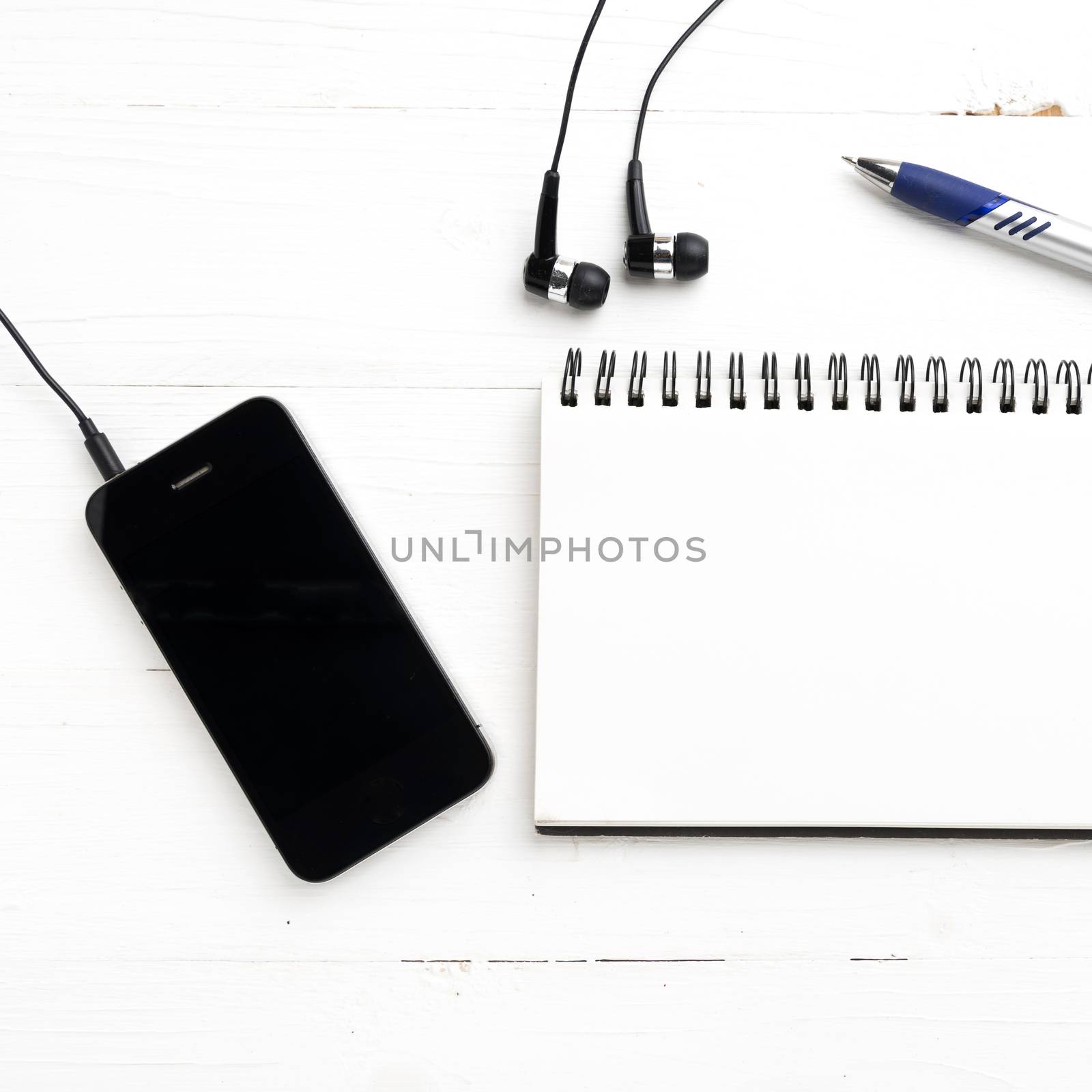 notepad and cellphone over white table