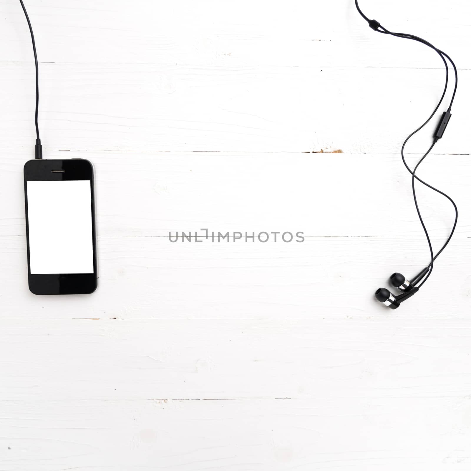 cellphone with earphone over white table