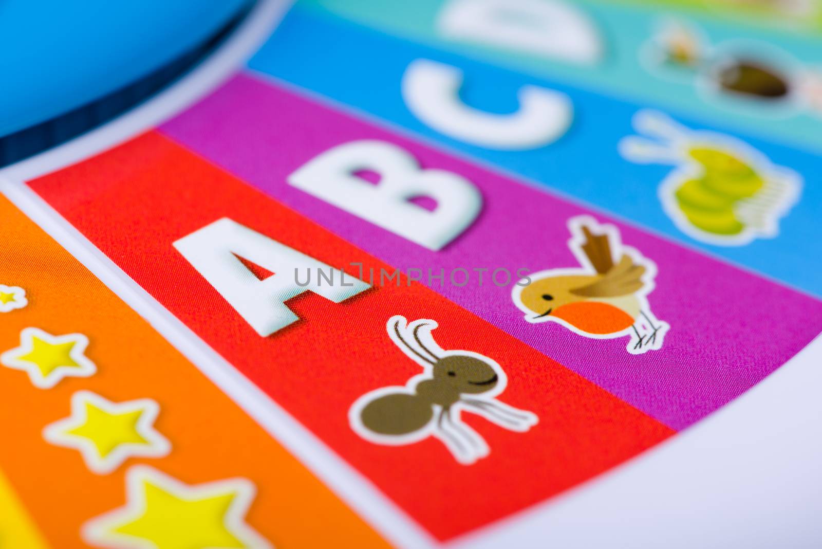 A close up shot of a colorful kid's toy with the ABCs, animals and stars on it.