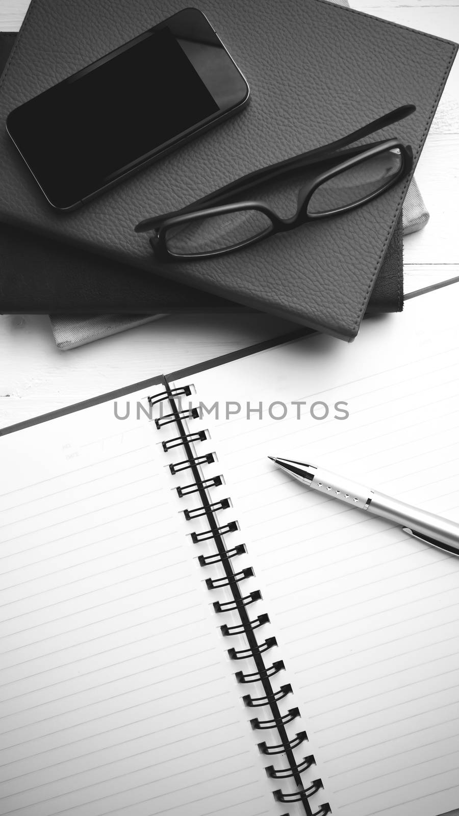 notepad with stack of book on table view from above black and white tone color style