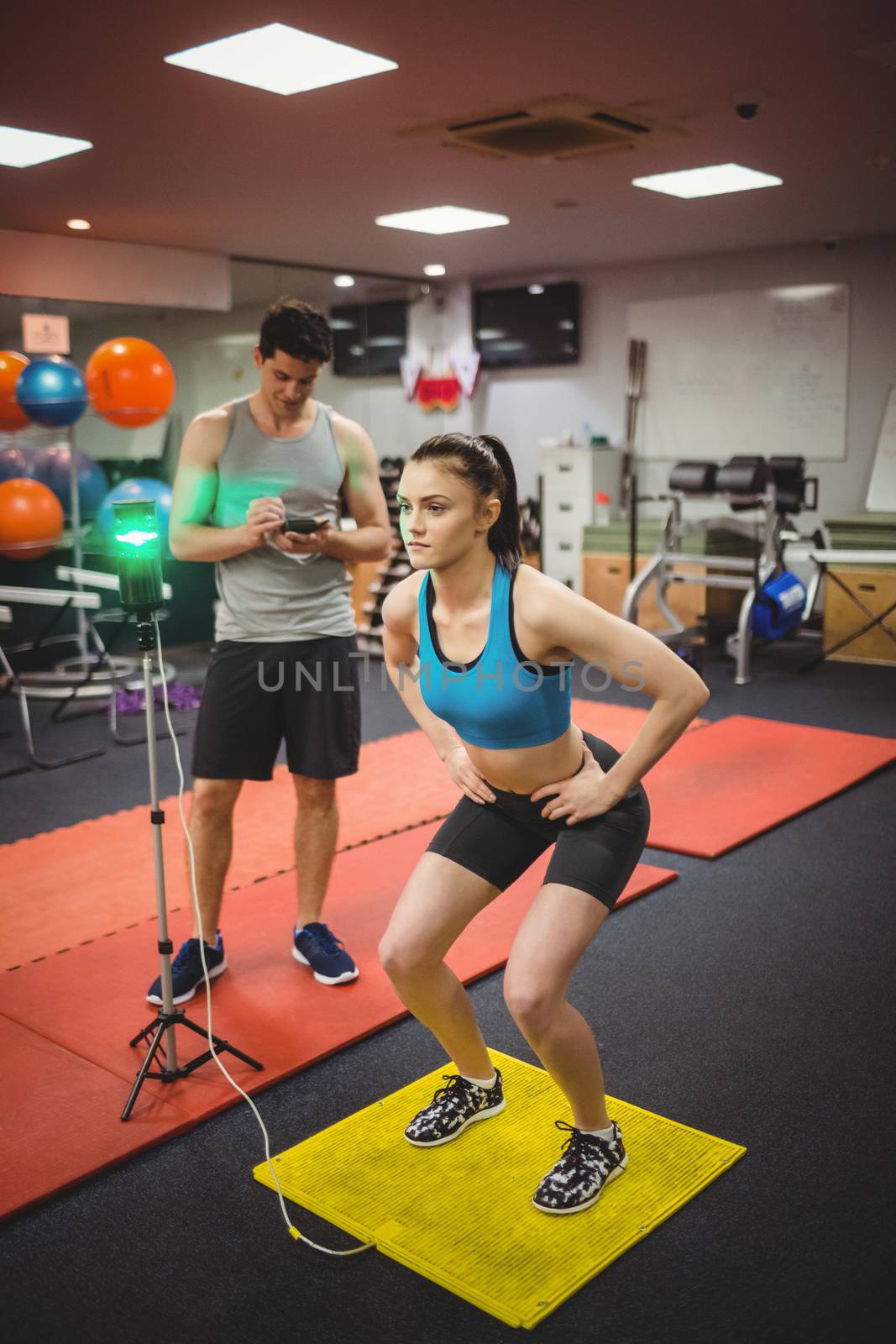 Fit woman measuring her jump with trainer by Wavebreakmedia