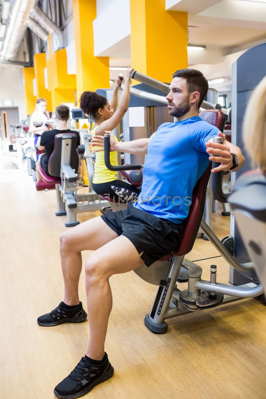 Fit people using weights machines at the gym