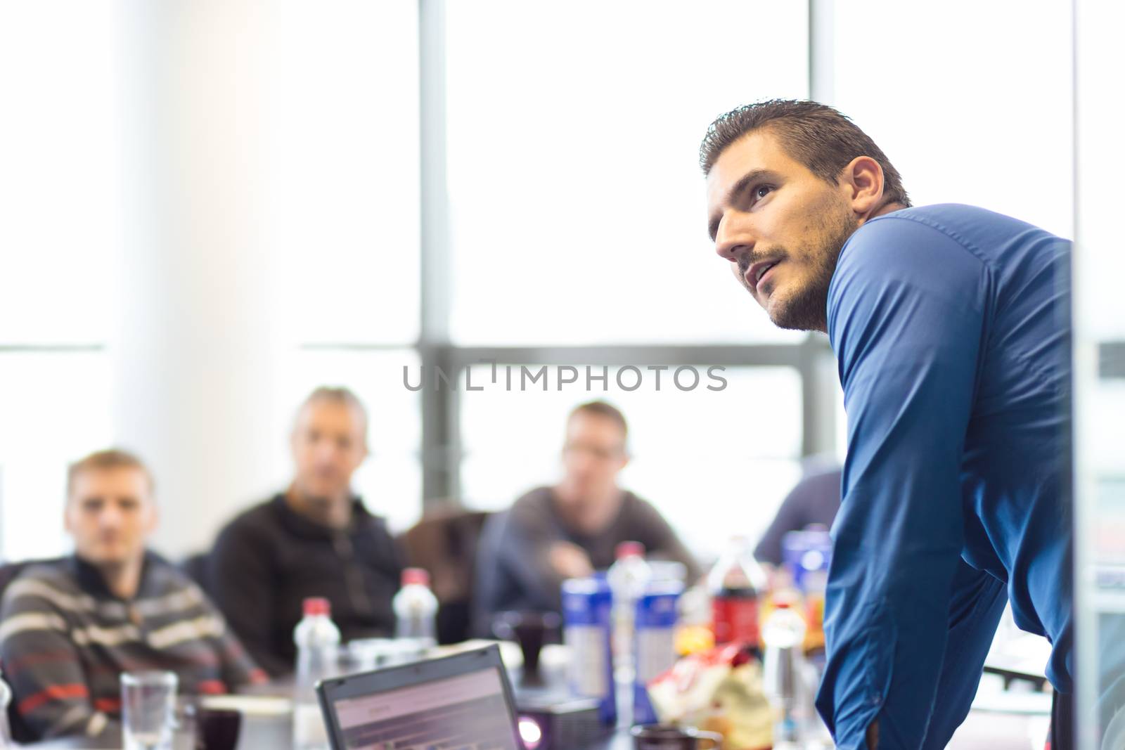 Business man making a presentation at office. Business executive delivering a presentation to his colleagues during meeting or in-house business training, explaining business plans to his employees.