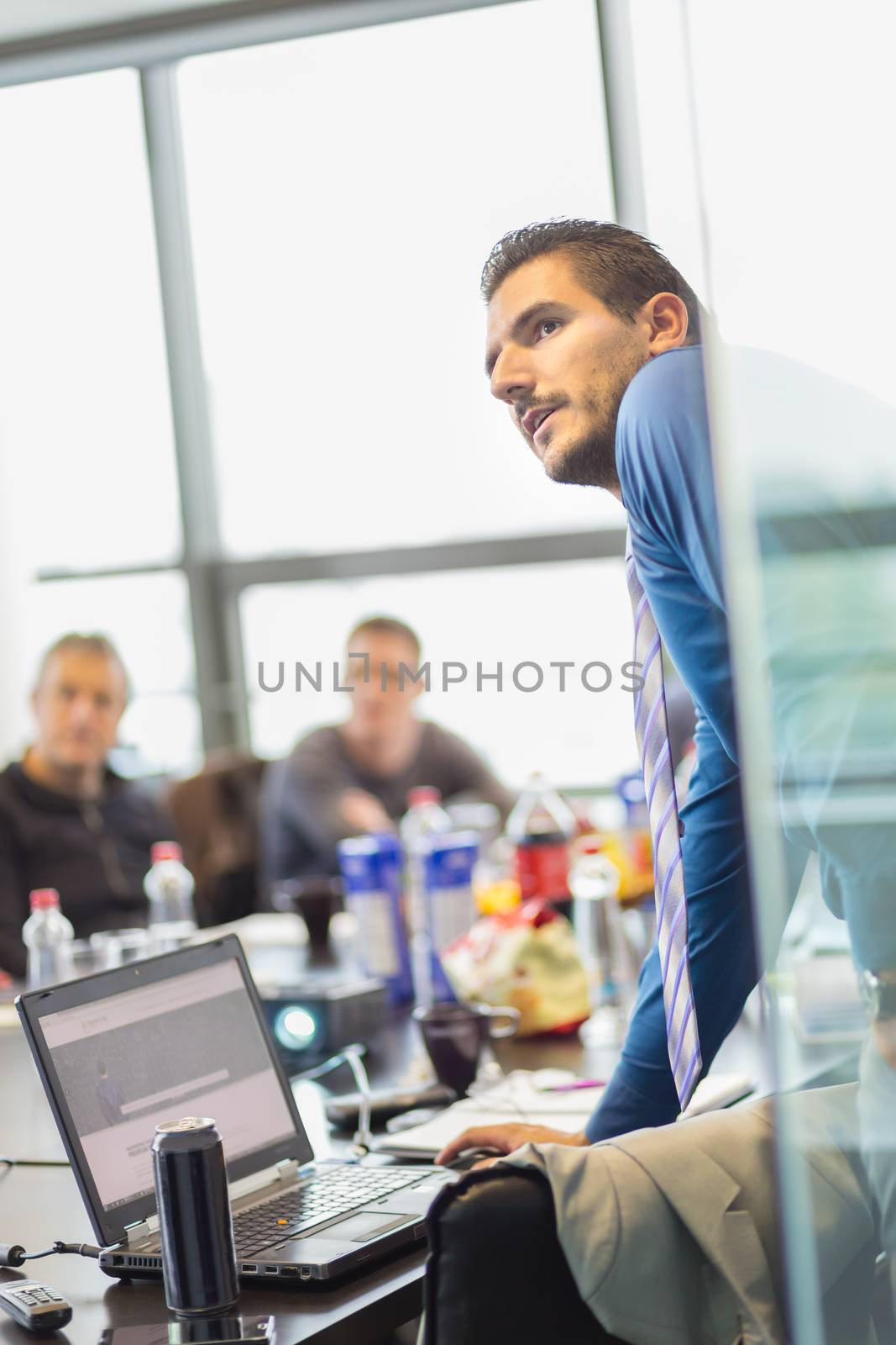 Business man making a presentation at office. Business executive delivering a presentation to his colleagues during meeting or in-house business training, explaining business plans to his employees.