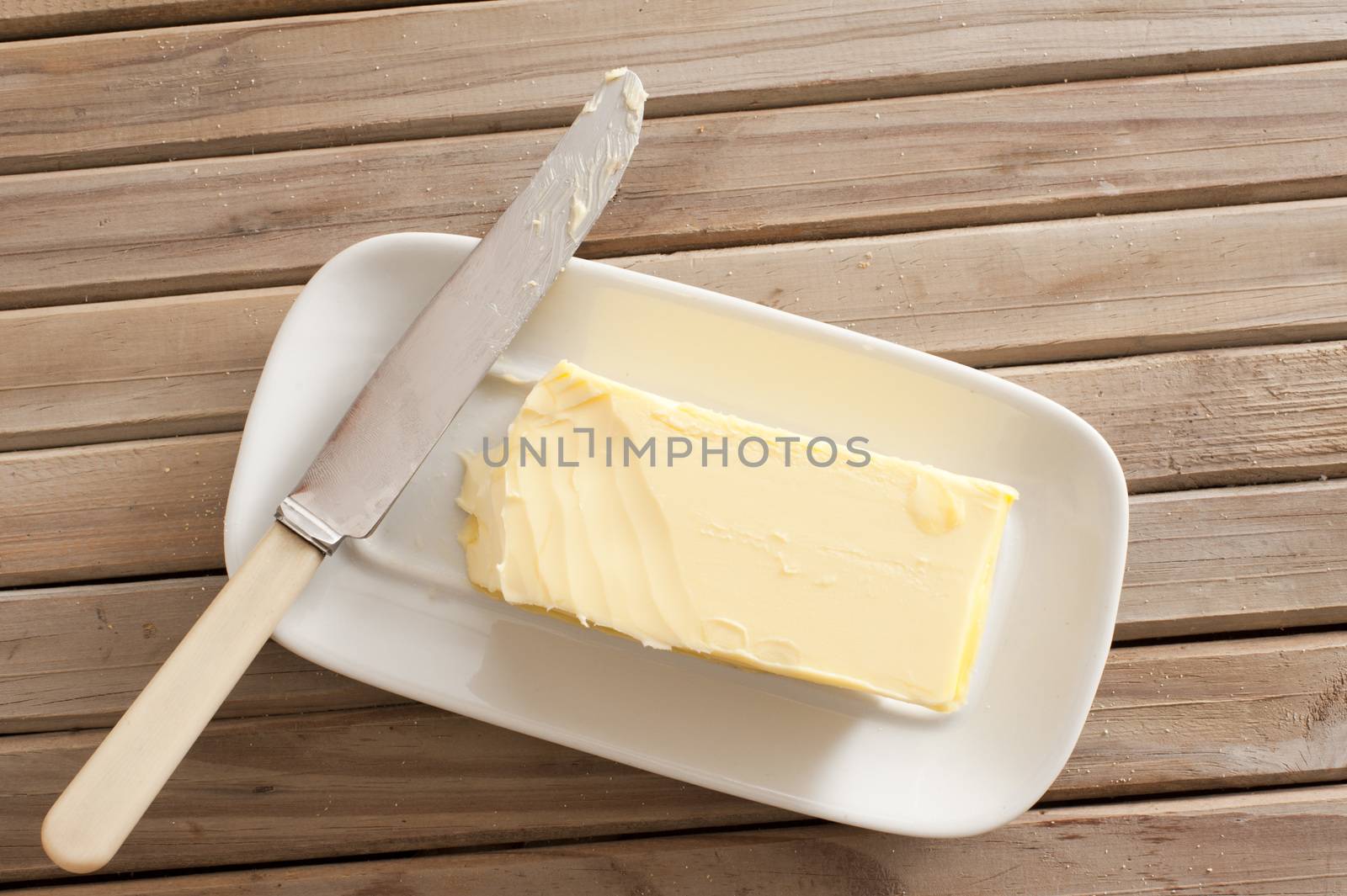 Pat of fresh farm butter on a dish by stockarch