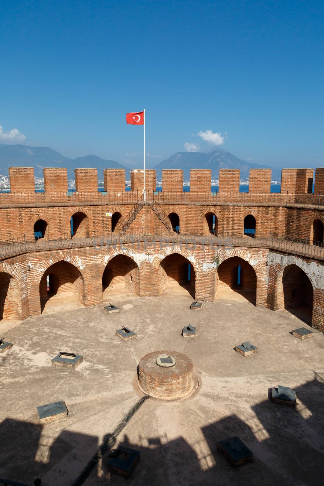View of Alanya Red Tower in Antalya  with orenge bricks, on bright blue sky background.