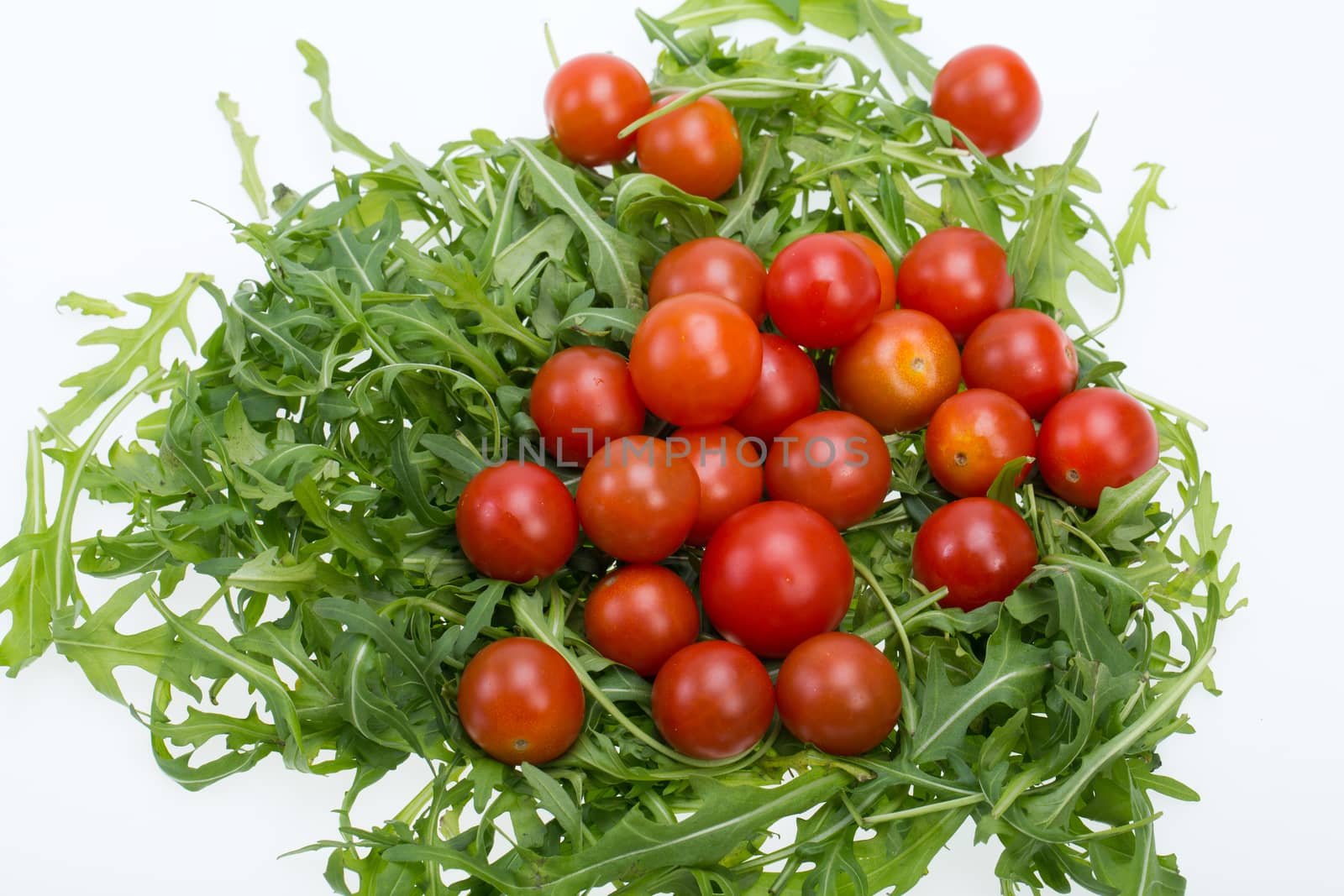 Heap of ruccola leaves and cherry tomatoes
