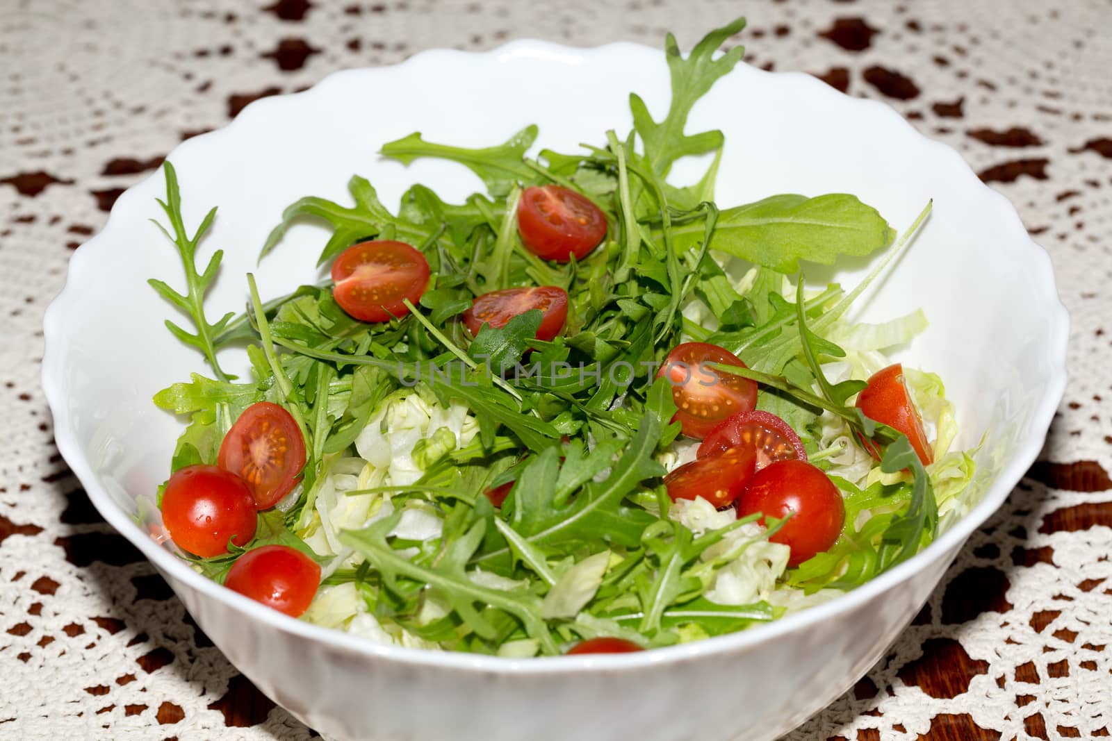Heap of ruccola, lettuce leaves and cherry tomatoes