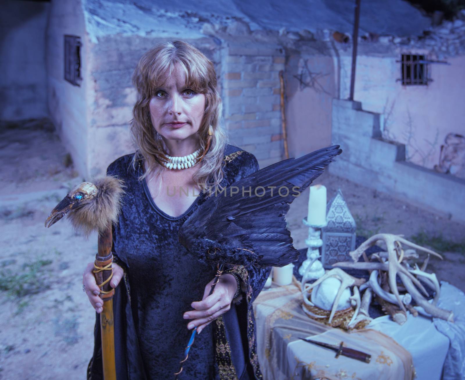 Serious female witch with altar and fetishes