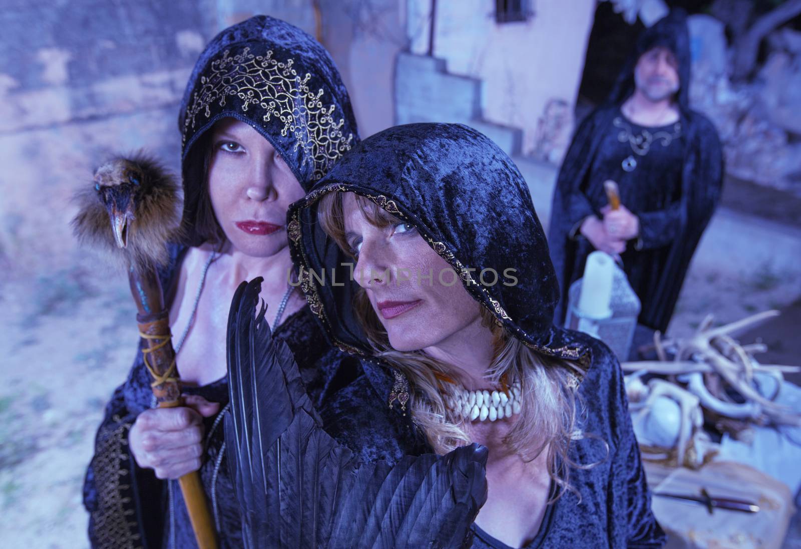 Group of witches in black robes near altar outdoors