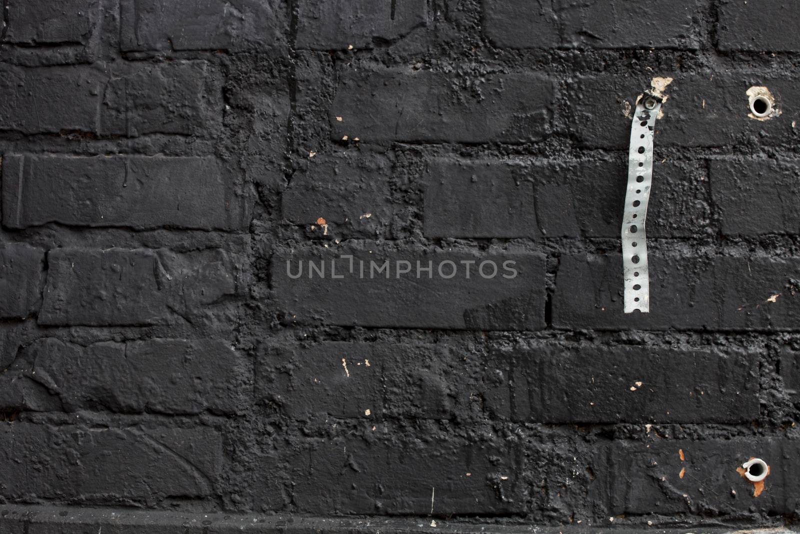 Brick wall painted with black paint.