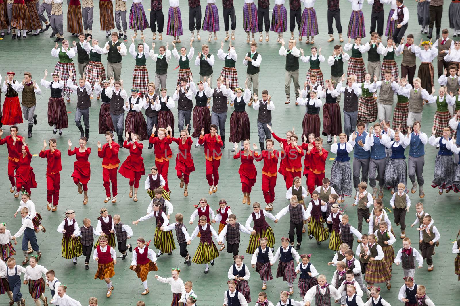 Dancers in traditional costumes perform at the Grand Folk dance concert of Latvian Youth Song and Dance Festival in the Daugava Stadium. by ints