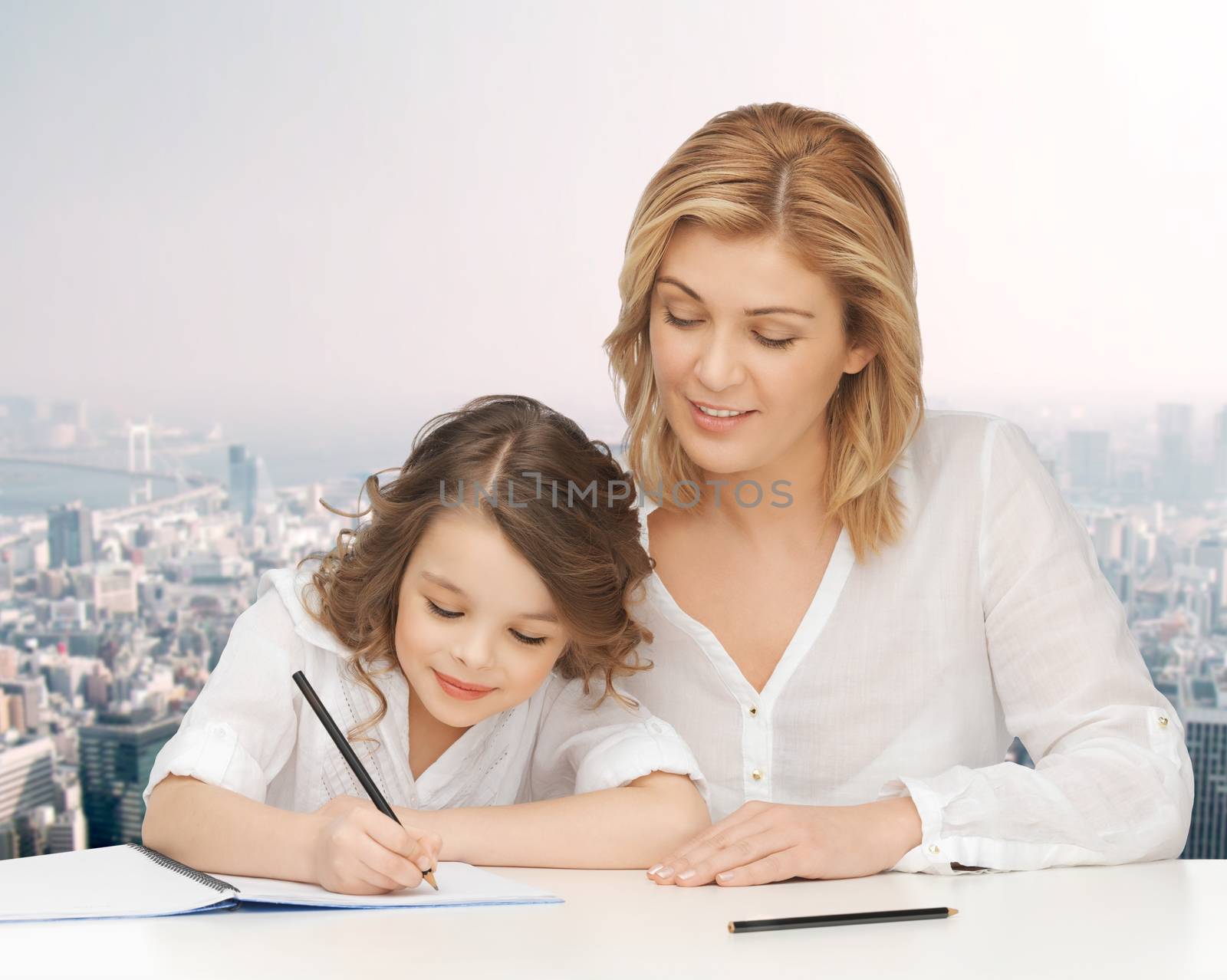 people, family, school, home education and parenting concept -happy mother and daughter doing homework and writing in notebook over city background