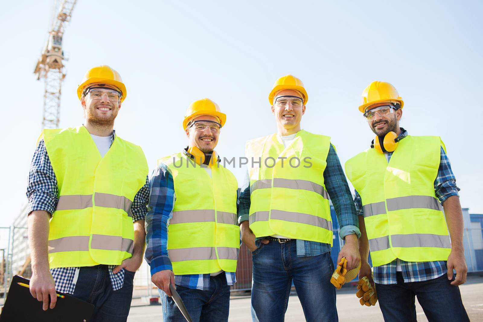 group of smiling builders with tablet pc outdoors by dolgachov