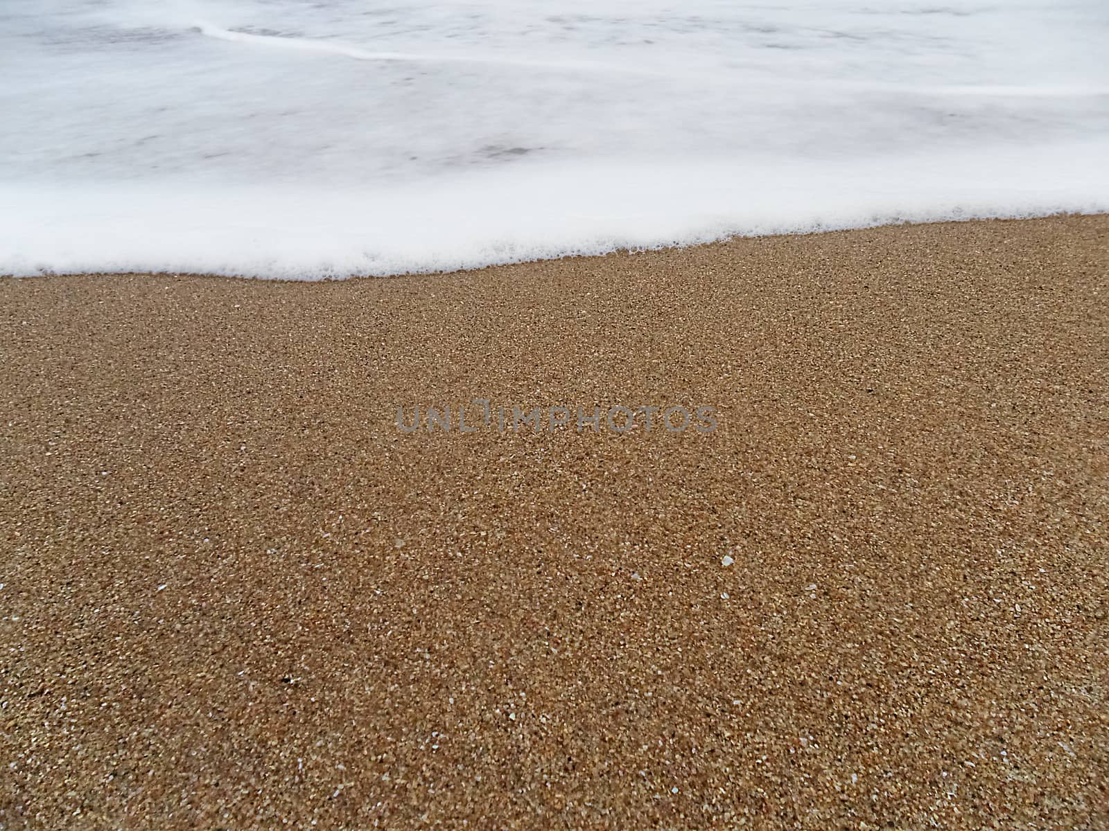 sandy beach with wave approaching by stockbp
