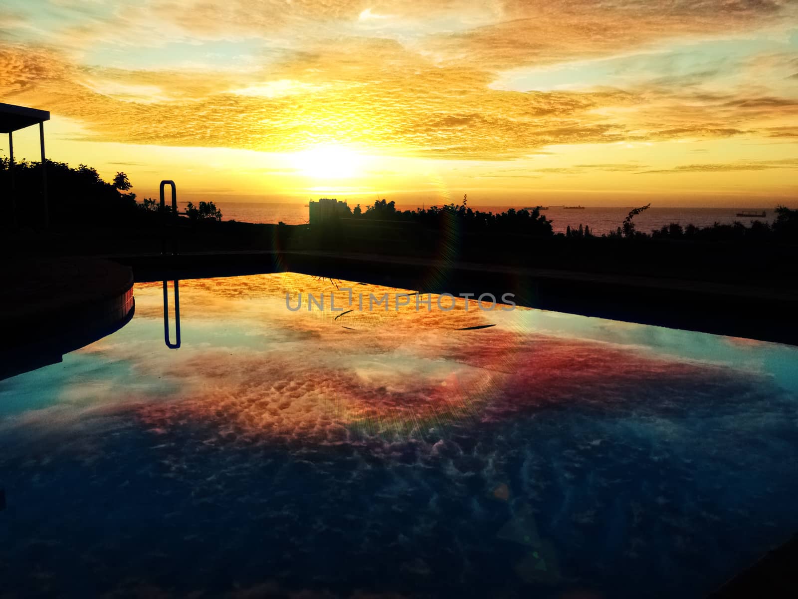 Sunset spreading light into clouds in africa over reflective pool