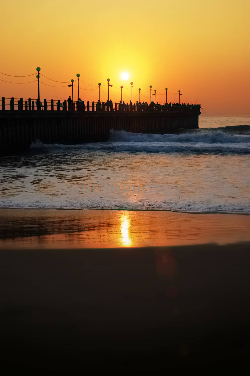 a Beatiful sunset over the pier of durban reflecting on ocean water