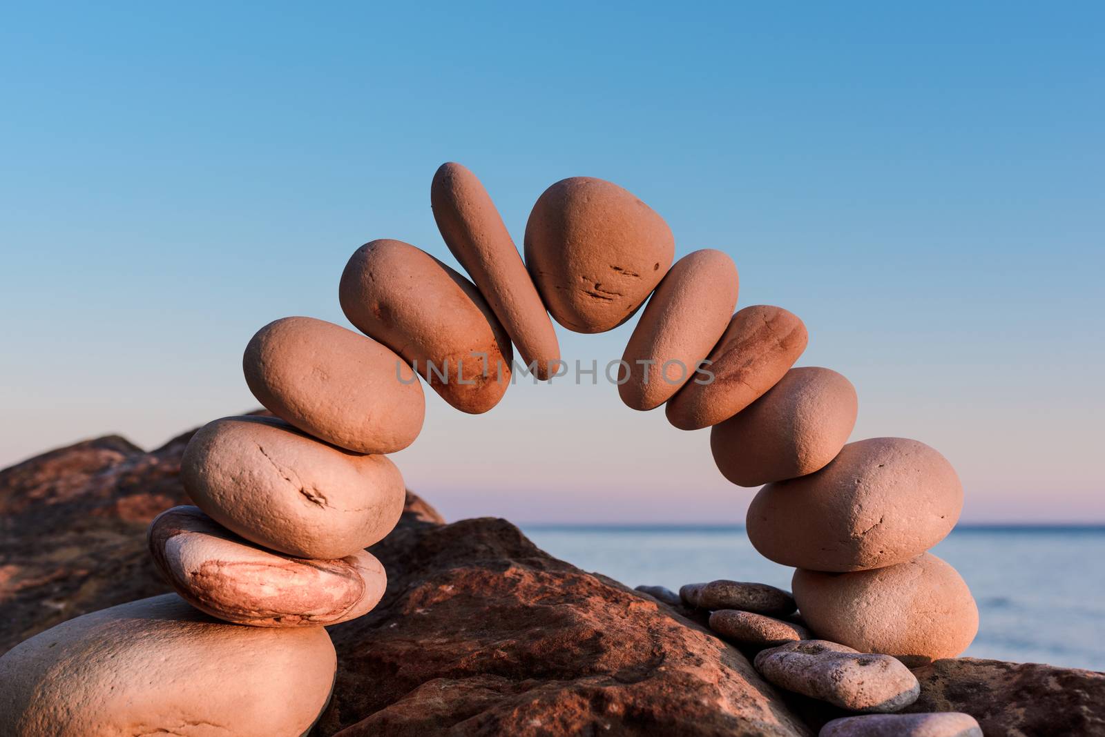 Curve of pebbles in the form of a arch on the coast