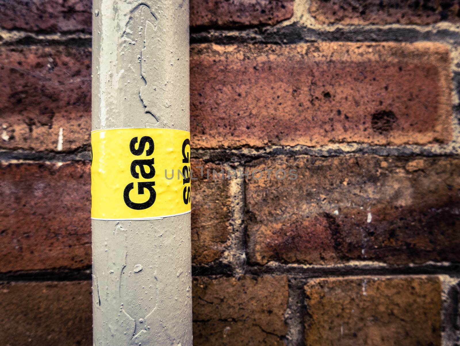 Detail Of A Residential Gas Pipe Against A Red Brick Wall